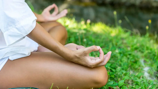 Femme assise sur l'herbe, en pleine méditation.
